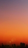 📱オレンジ色の綺麗な夕日とビルの影 iPhone 14 Pro 壁紙・待ち受け