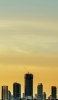 📱綺麗な黄色いグラデーションの空 高層ビル iPhone 14 Pro Max 壁紙・待ち受け
