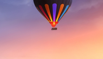📱海上を飛ぶカラフルな気球 iPhone 14 Plus 壁紙・待ち受け