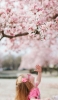 📱桜を見上げる外国人の女の子 iPhone 14 Pro 壁紙・待ち受け