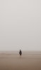 📱海辺 砂浜を歩く男性 iPhone 14 Pro 壁紙・待ち受け