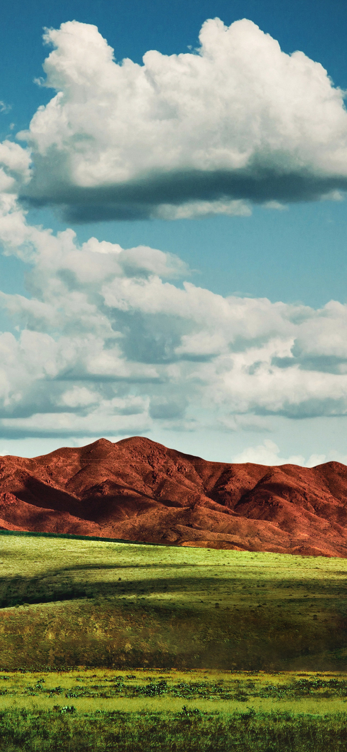 茶色の山と芝生と雲の多い空 Iphone 11 Pro スマホ壁紙 待ち受け スマラン