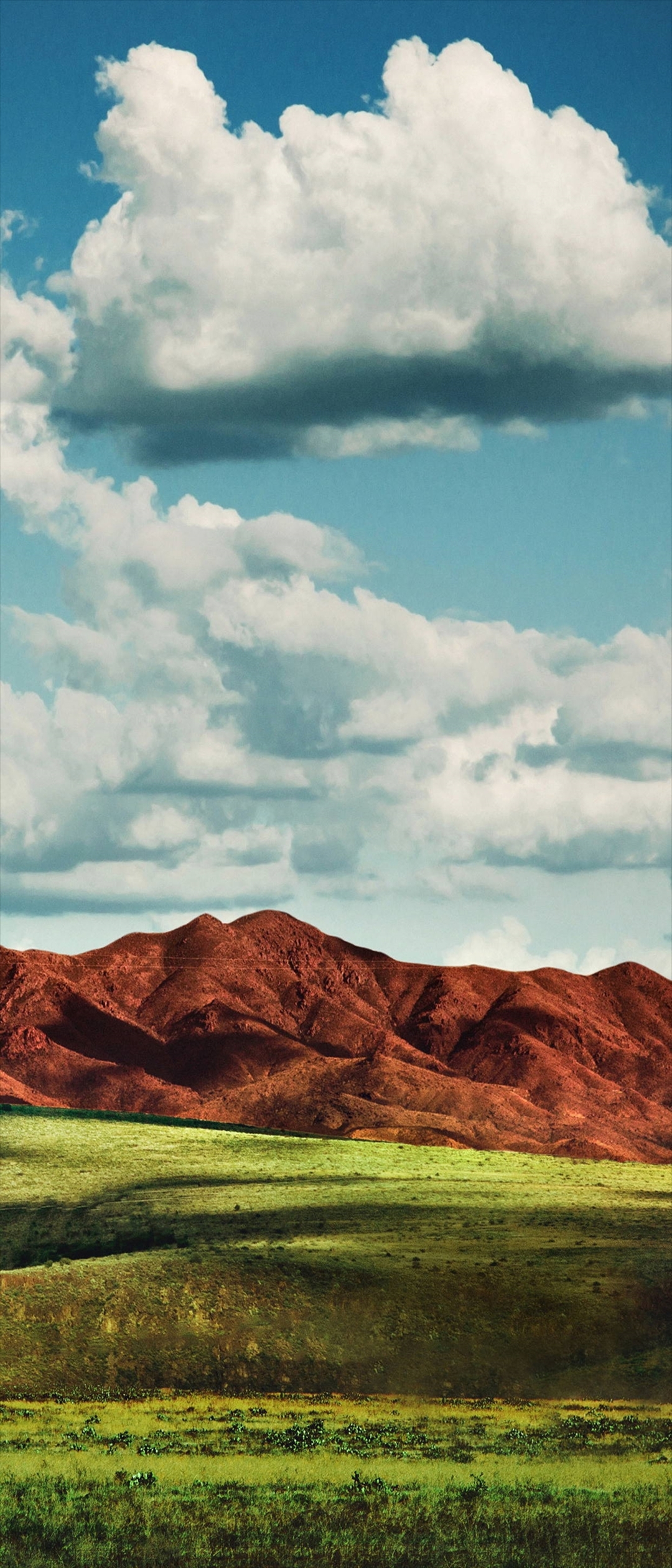 赤土色の山と緑の平原と青空 Xperia 8 Lite Androidスマホ壁紙 待ち受け スマラン