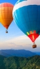 📱山の上を飛ぶ二つの気球 iPhone 13 Pro 壁紙・待ち受け
