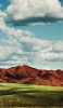 📱青空と赤土色の小さい山と草原 iPhone 11 Pro Max 壁紙・待ち受け