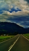 📱綺麗な青空と山と真っすぐ伸びる黒い道路 iPhone 6s 壁紙・待ち受け