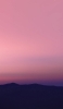 📱朝焼け時のピンクの空と山のシルエット iPhone SE (第3世代) 壁紙・待ち受け
