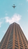 📱茶色い高層ビルと飛行機 Google Pixel 5a 壁紙・待ち受け