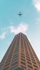 📱茶色い高層ビルと飛行機 Google Pixel 6 Pro 壁紙・待ち受け
