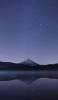 📱夜の銀河と湖に鏡面する山 iPhone 13 mini 壁紙・待ち受け
