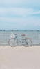 📱海と水色の自転車 iPhone 13 mini 壁紙・待ち受け