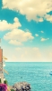 📱綺麗な水色の空と海と断崖の建物 AQUOS sense5G 壁紙・待ち受け
