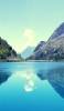📱澄んだ青空と緑残る岩山と綺麗な湖 iPhone 12 壁紙・待ち受け