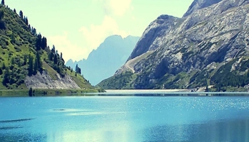📱澄んだ青空と緑残る岩山と綺麗な湖 iPhone 12 壁紙・待ち受け