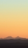 📱薄い緑・オレンジのグラデーションの空 黒い山 Redmi Note 10 Pro 壁紙・待ち受け